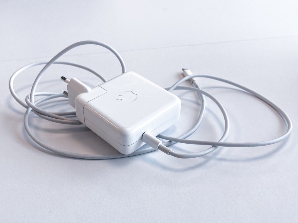 white apple charging adapter on white table