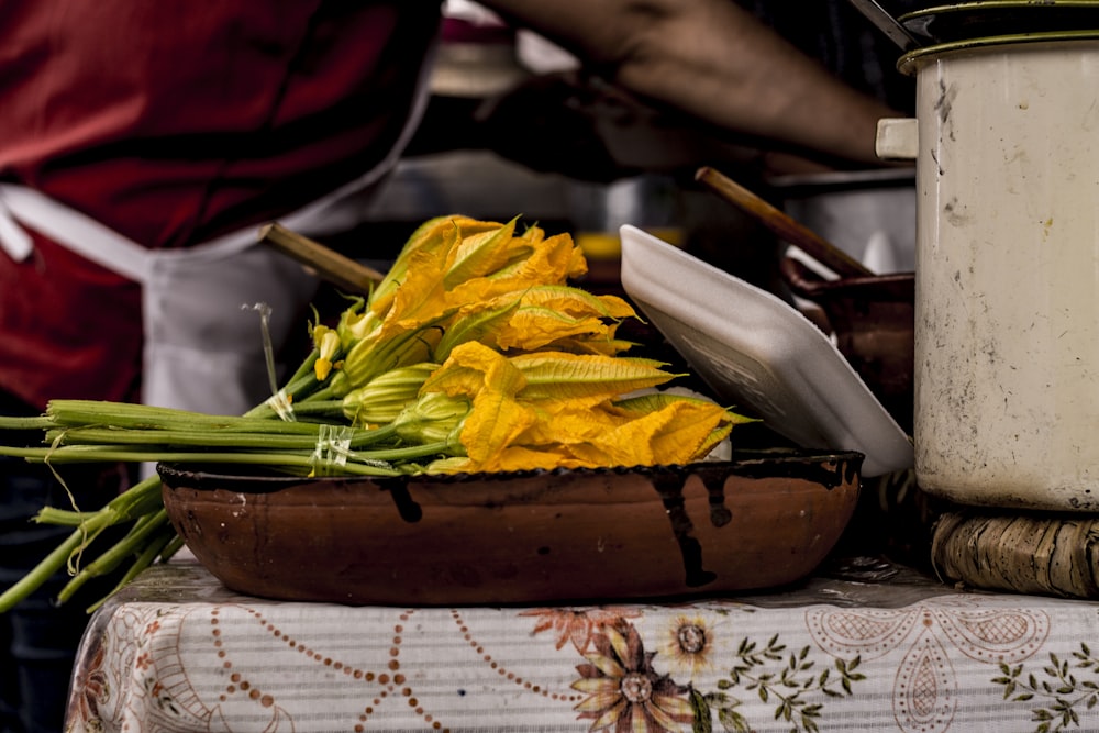 yellow and white flowers on brown wooden bowl