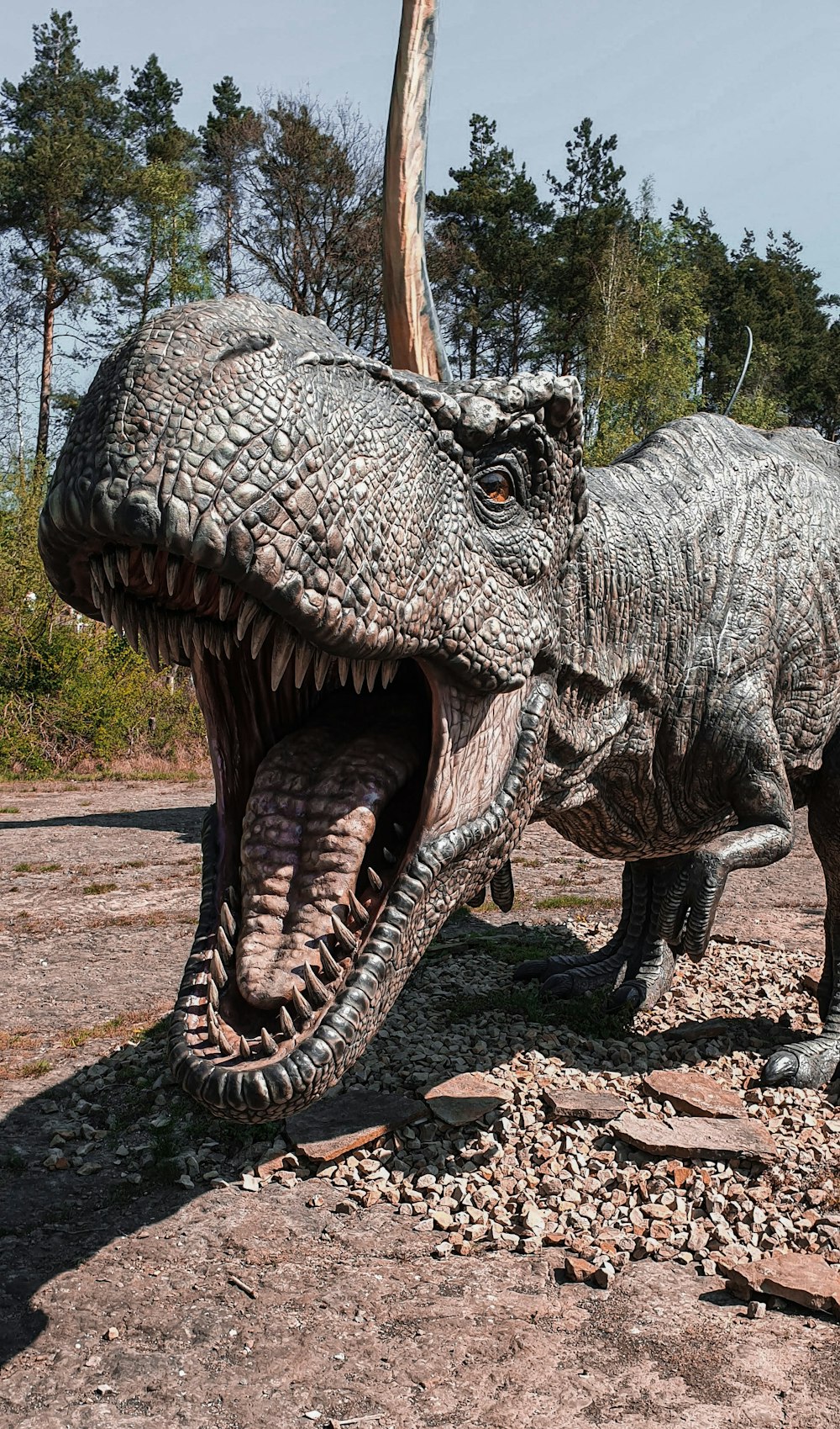 estátua cinzenta e preta do dinossauro