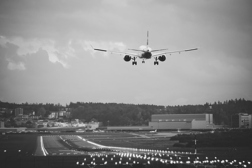 Foto en escala de grises de un avión en el cielo