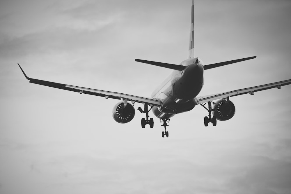 grayscale photo of airplane in mid air