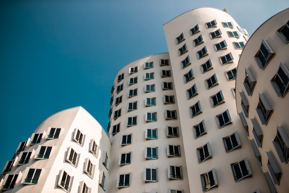 Bâtiment en béton blanc sous le ciel bleu pendant la journée