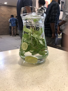 A countertop water filter pitcher with clear water inside.