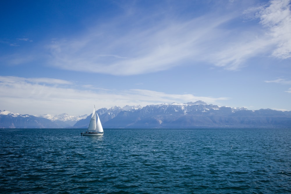 white sailboat on sea under blue sky during daytime