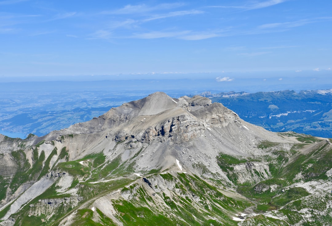 green and gray mountain beside blue sea under blue sky during daytime