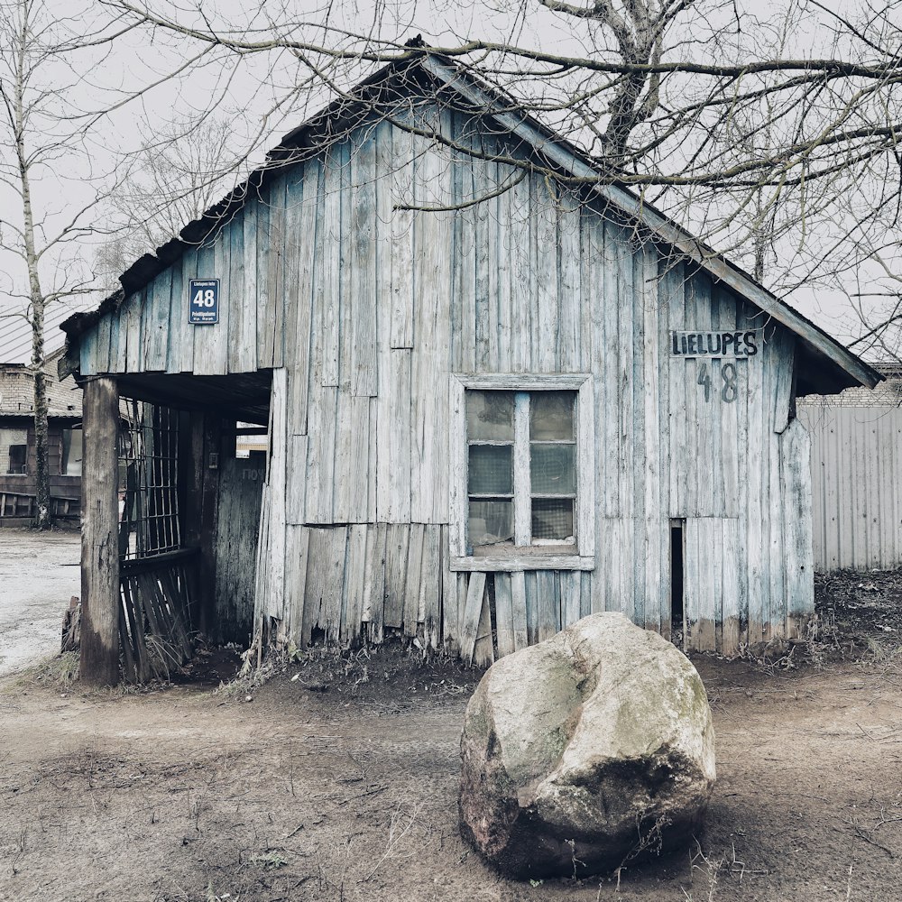 brown wooden house near bare trees during daytime