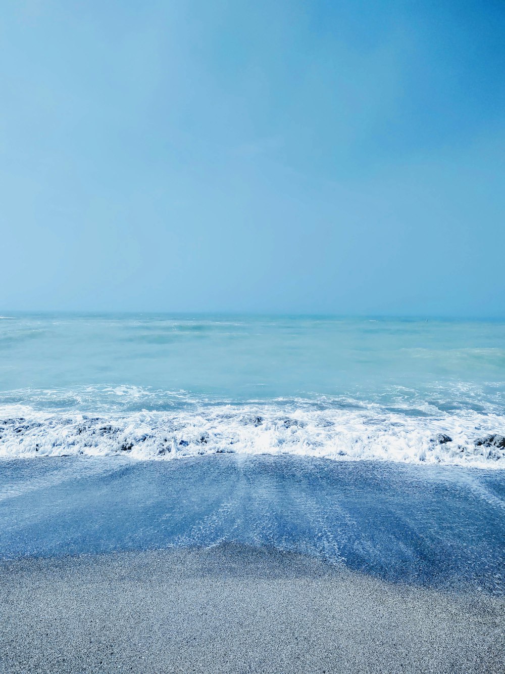 ocean waves crashing on shore during daytime