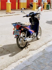 black and red motorcycle parked on gray concrete road during daytime