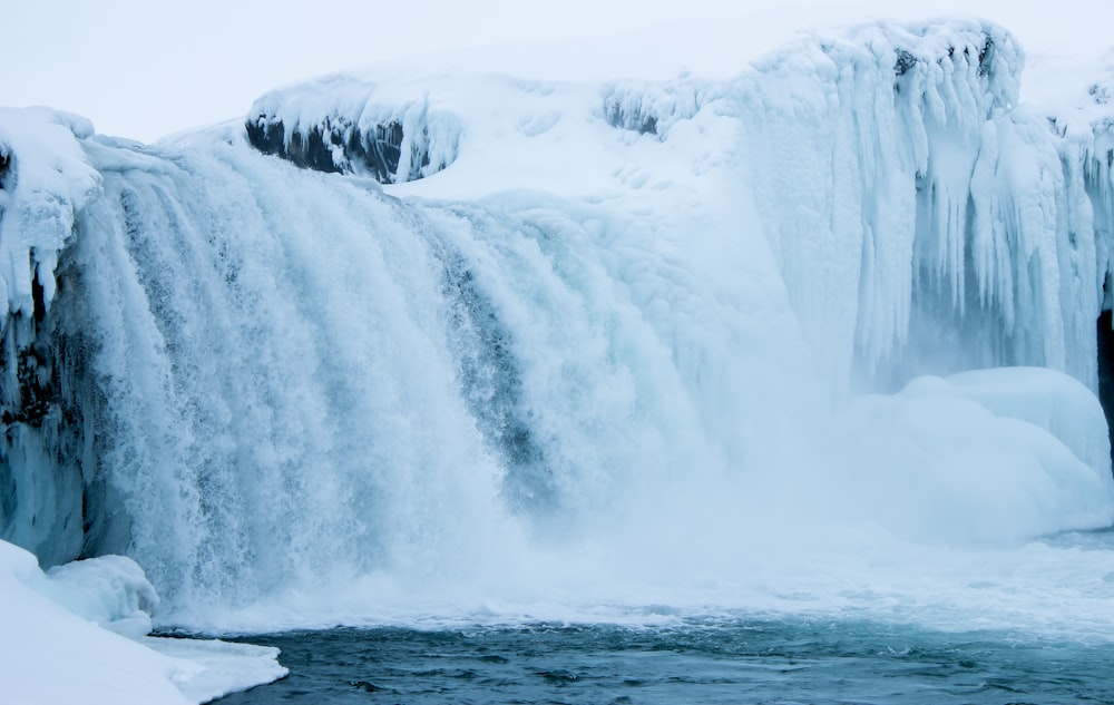 white waterfalls on gray rocky mountain during daytime