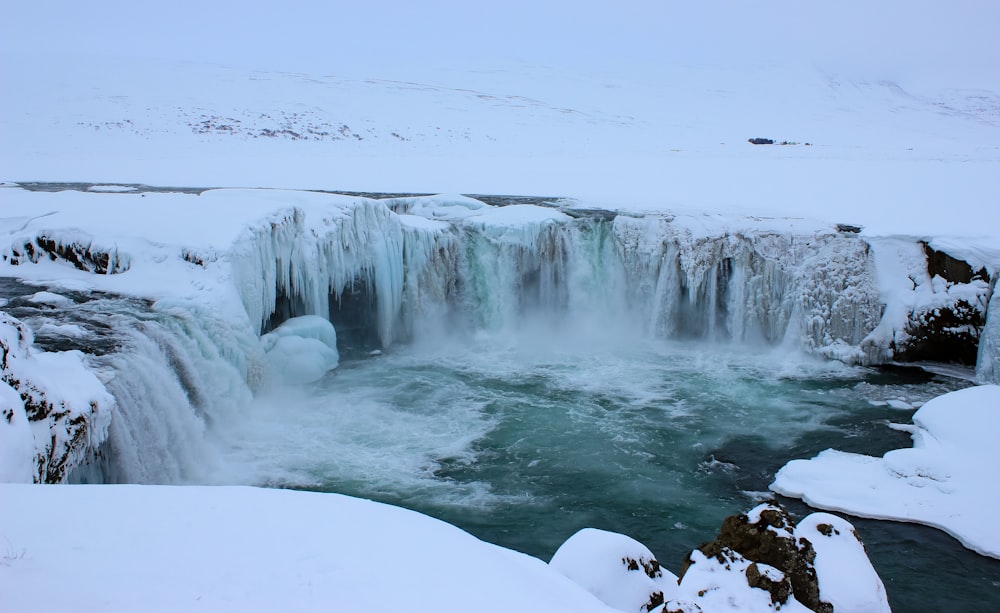 water falls on snow covered ground during daytime