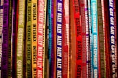 Colorful ribbons featuring words related to gender identity and sexual orientation hang vertically. Each ribbon displays labels like lesbian, bisexual, intersex, transgender, and ally, among others. The ribbons are in a vibrant array of shades, creating a rainbow effect.
