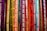 Colorful ribbons featuring words related to gender identity and sexual orientation hang vertically. Each ribbon displays labels like lesbian, bisexual, intersex, transgender, and ally, among others. The ribbons are in a vibrant array of shades, creating a rainbow effect.