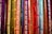 Colorful ribbons featuring words related to gender identity and sexual orientation hang vertically. Each ribbon displays labels like lesbian, bisexual, intersex, transgender, and ally, among others. The ribbons are in a vibrant array of shades, creating a rainbow effect.