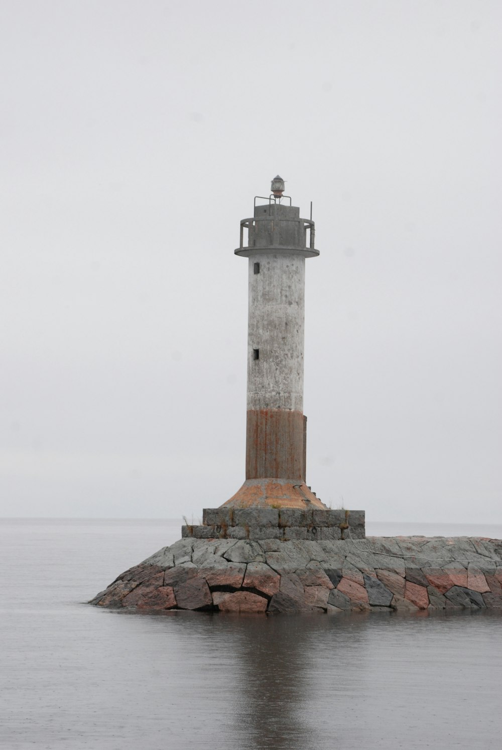 white and brown lighthouse near sea during daytime