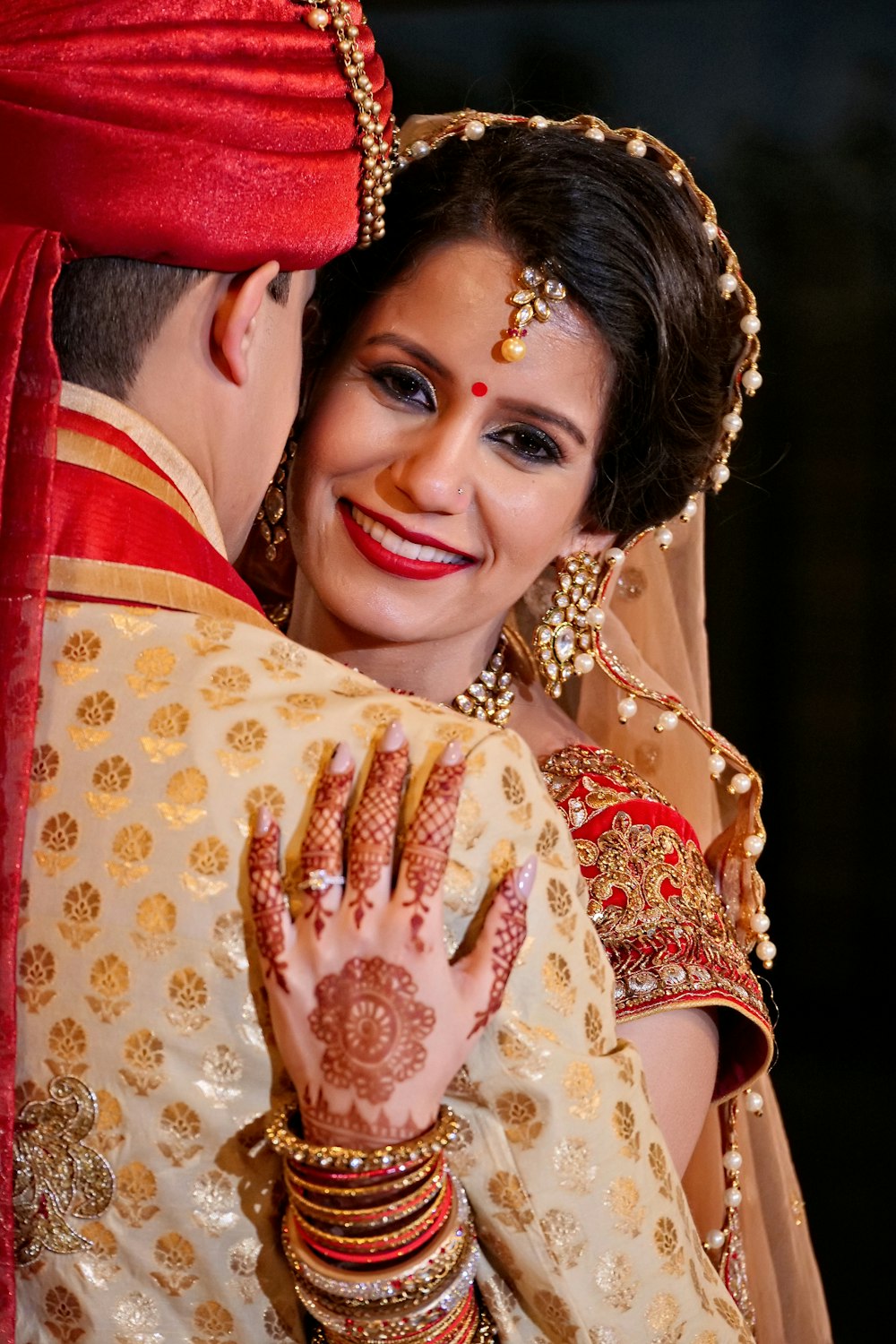 Mujer sonriente con hiyab floral rojo y blanco