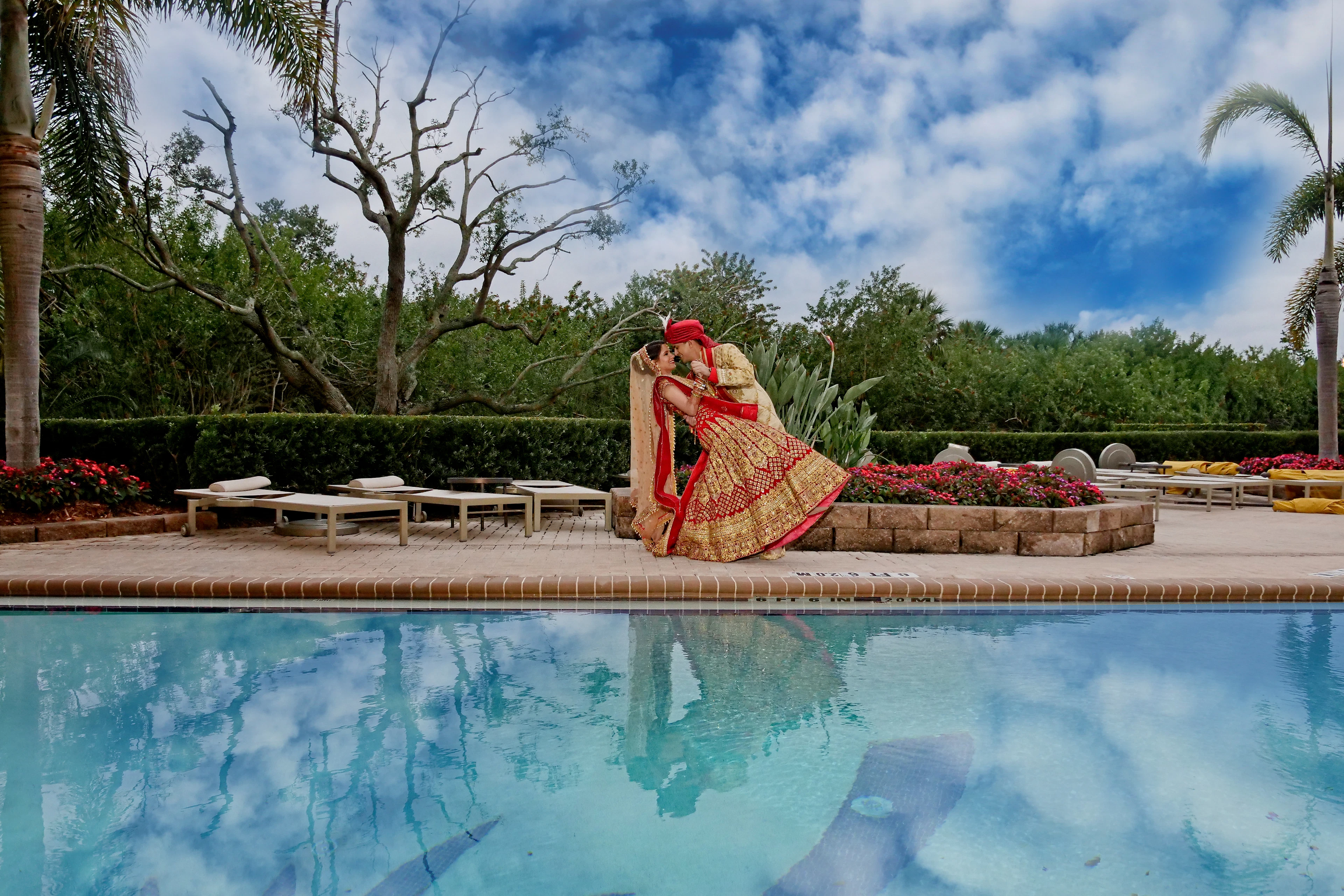 Bride seated beside an infinity pool