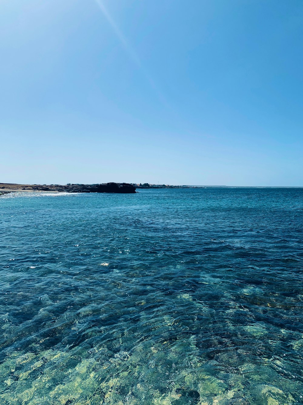 Mar azul bajo el cielo azul durante el día