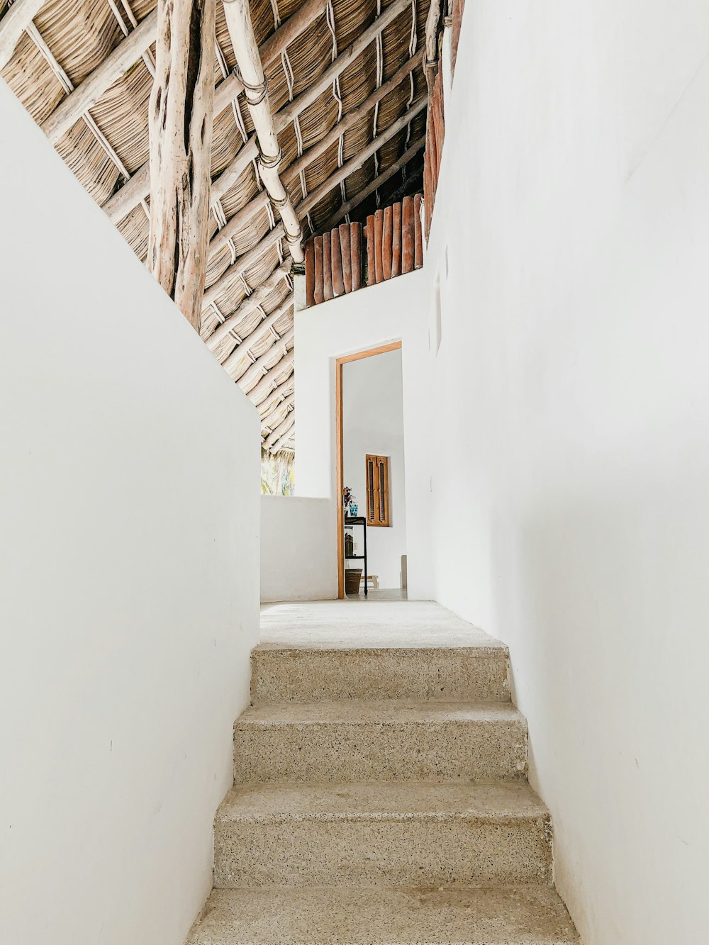 white concrete staircase with brown wooden railings