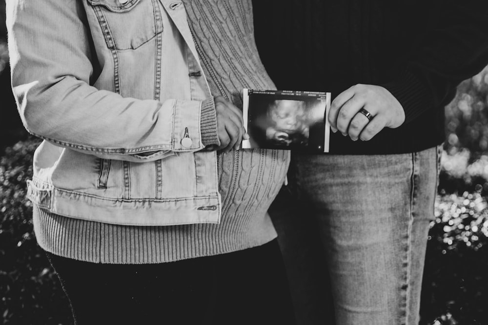grayscale photo of person holding photo