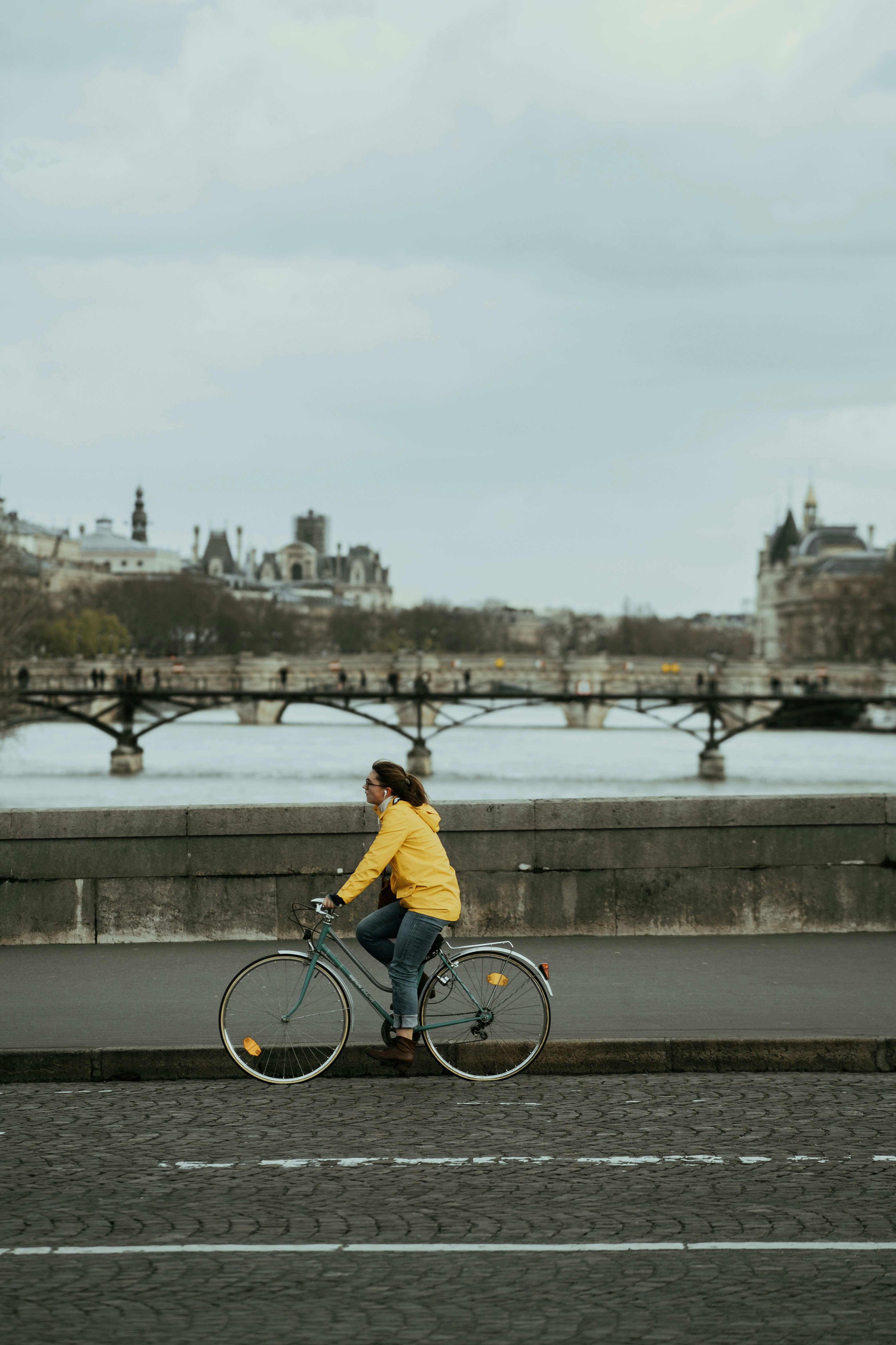 man in yellow shirt riding bicycle on bridge during daytime