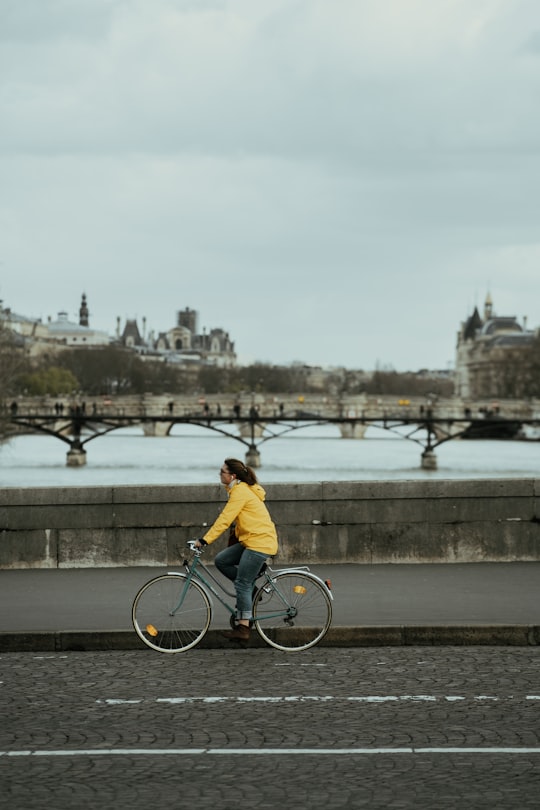 man in yellow shirt riding bicycle on bridge during daytime in Pont du Carrousel France