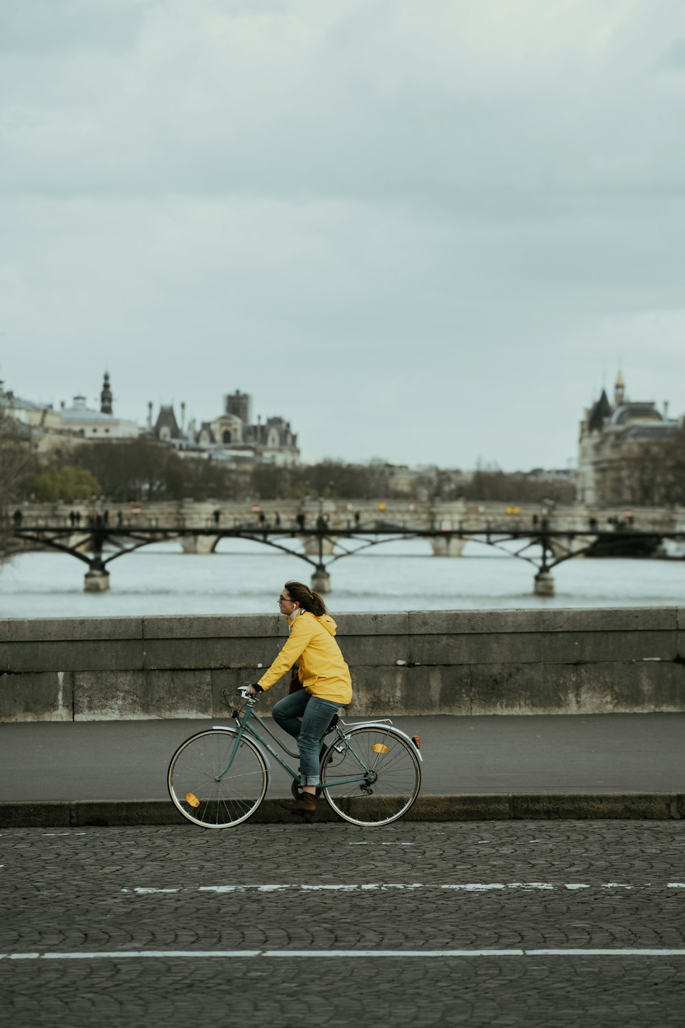 man in yellow shirt riding bicycle on bridge during daytime