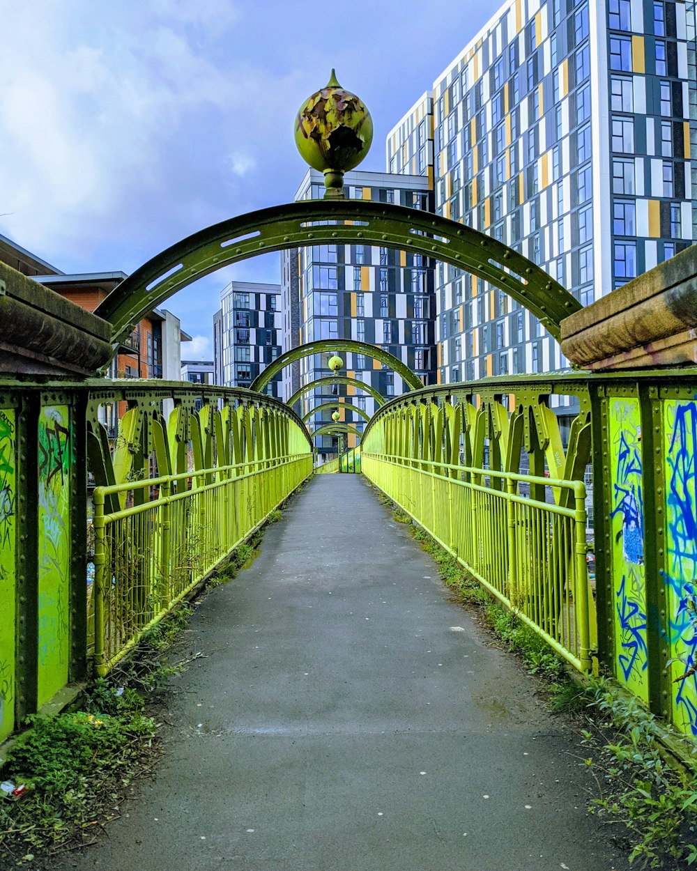 green metal fence near building during daytime