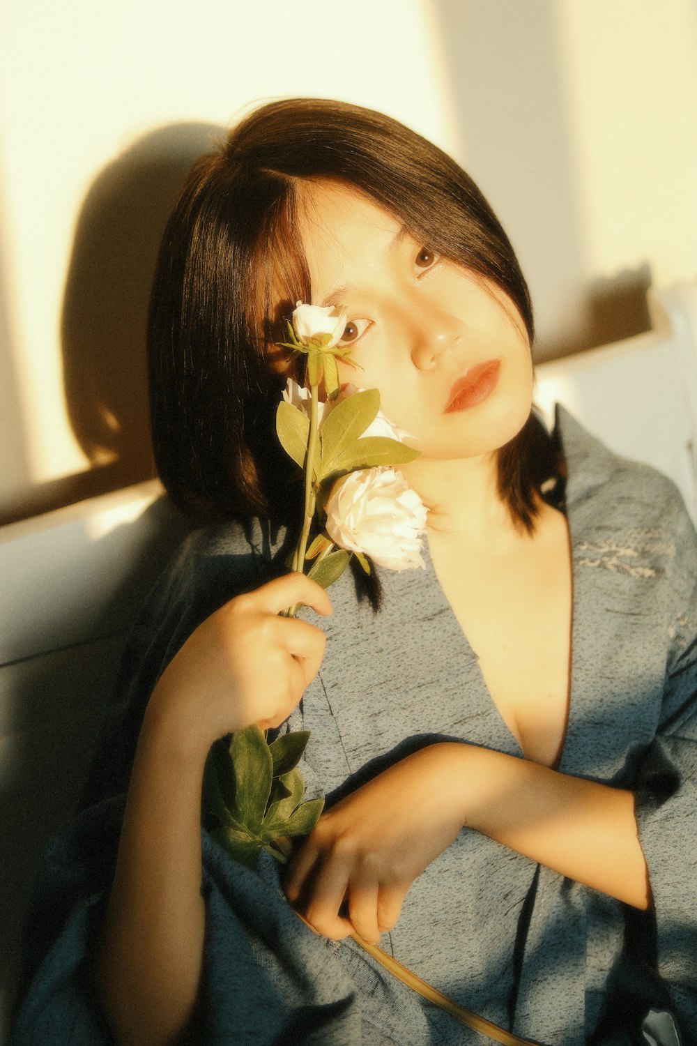 woman in gray tank top holding white flower