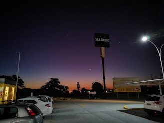 A busy parking lot with neatly parked cars under evening lights at Parkfacil Estacionamento