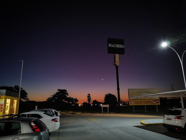 A busy parking lot with neatly parked cars under evening lights at Parkfacil Estacionamento