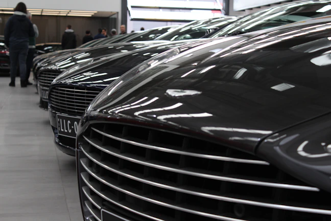 A row of premium cars lined up neatly in the dealership under soft lighting.