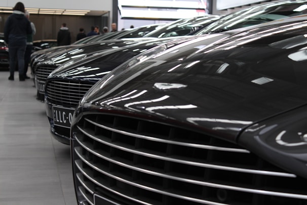 Rows of shiny cars lined up in a large warehouse ready for shipment.