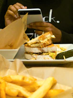 User enjoying a meal with the MoodFood app open on their phone beside them.