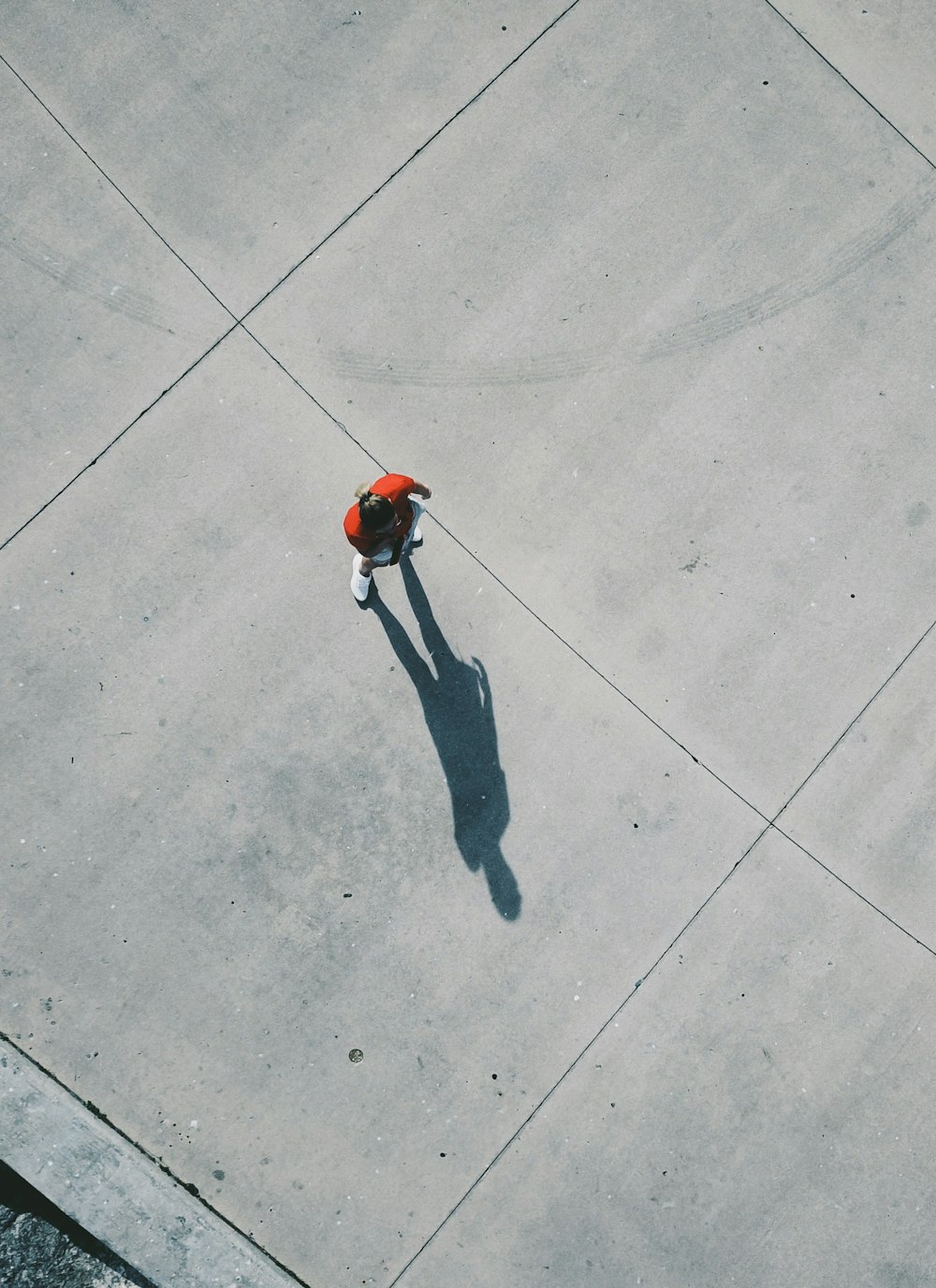 person in black pants walking on gray concrete floor