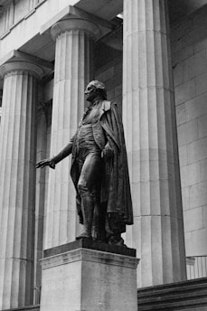 A black and white historical photo of John F. Kennedy giving a speech.