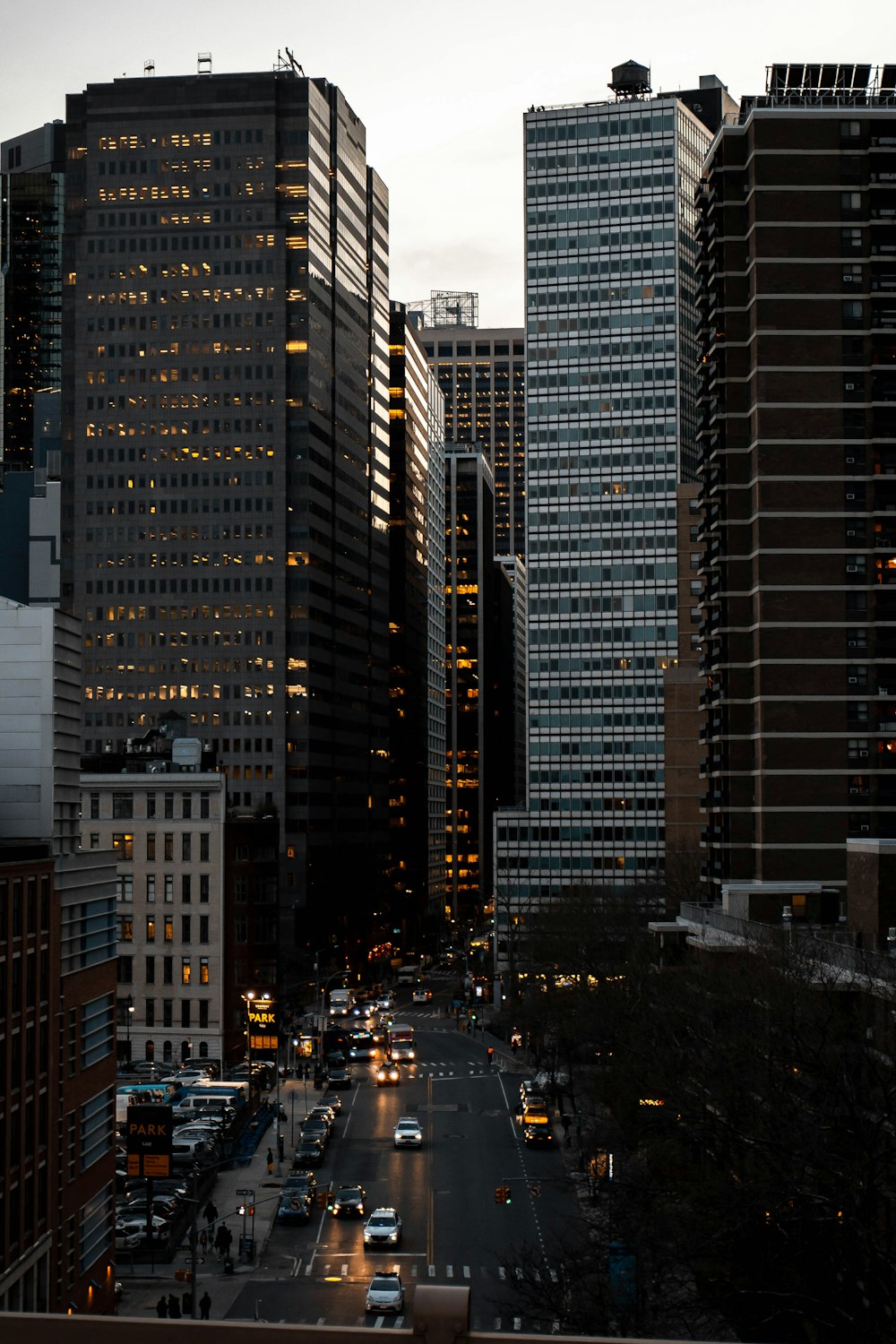 cars on road in between high rise buildings during night time