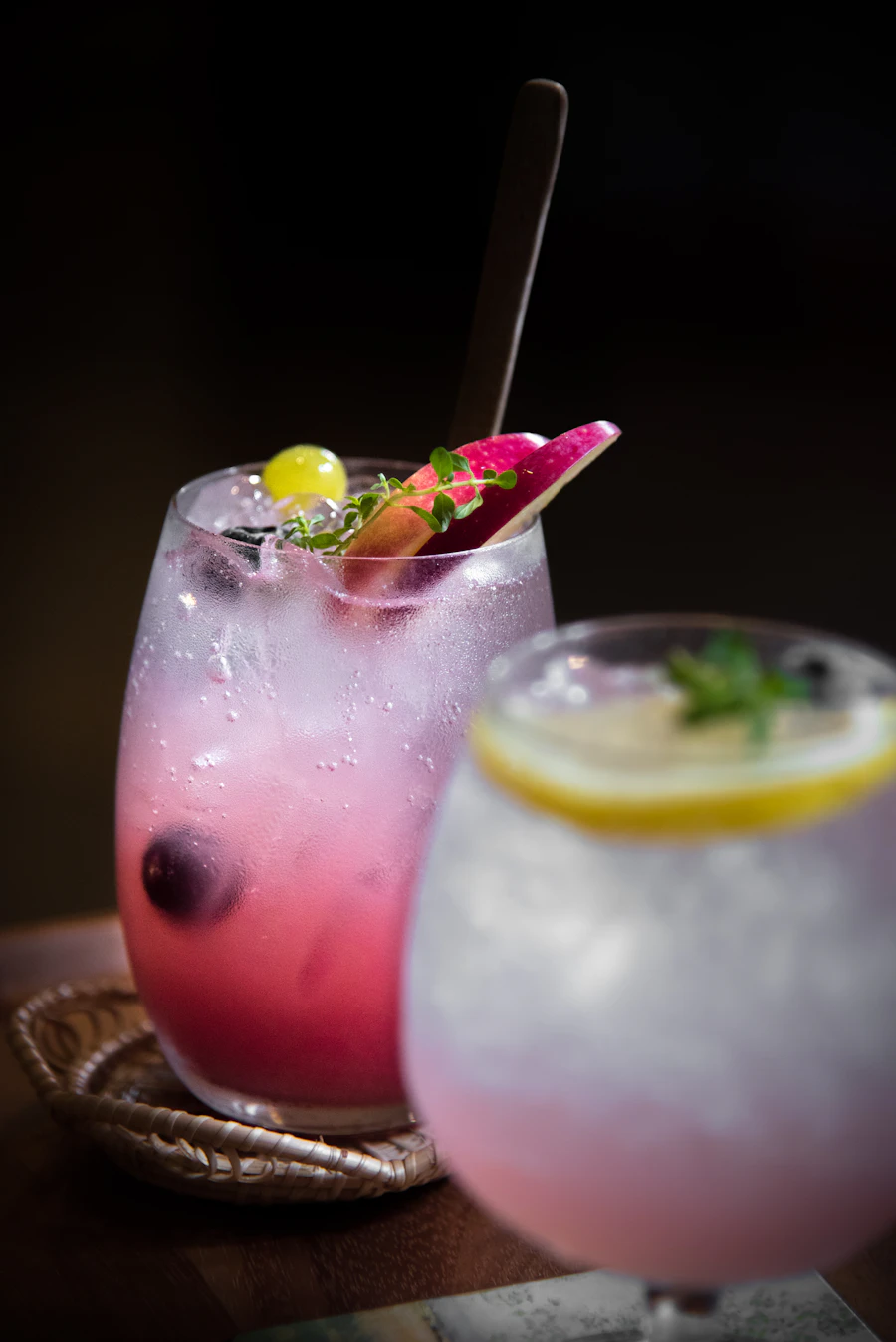 Two colorful sparkling drinks over ice