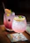Close-up of a beautifully garnished mocktail with fresh fruit and herbs on a clean white table.