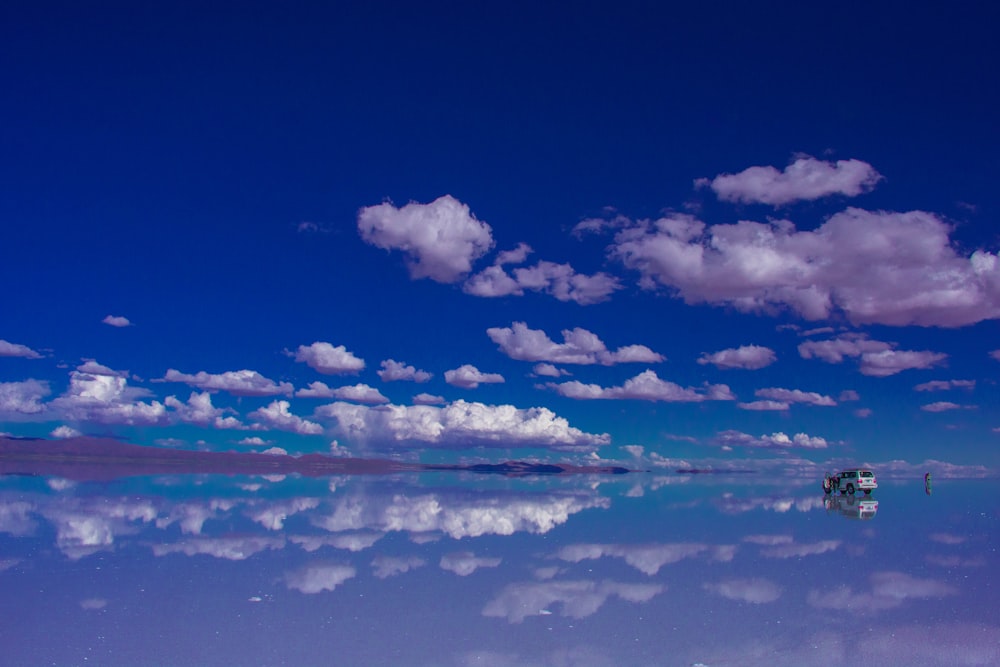 blauer Himmel und weiße Wolken über ruhigem Meer