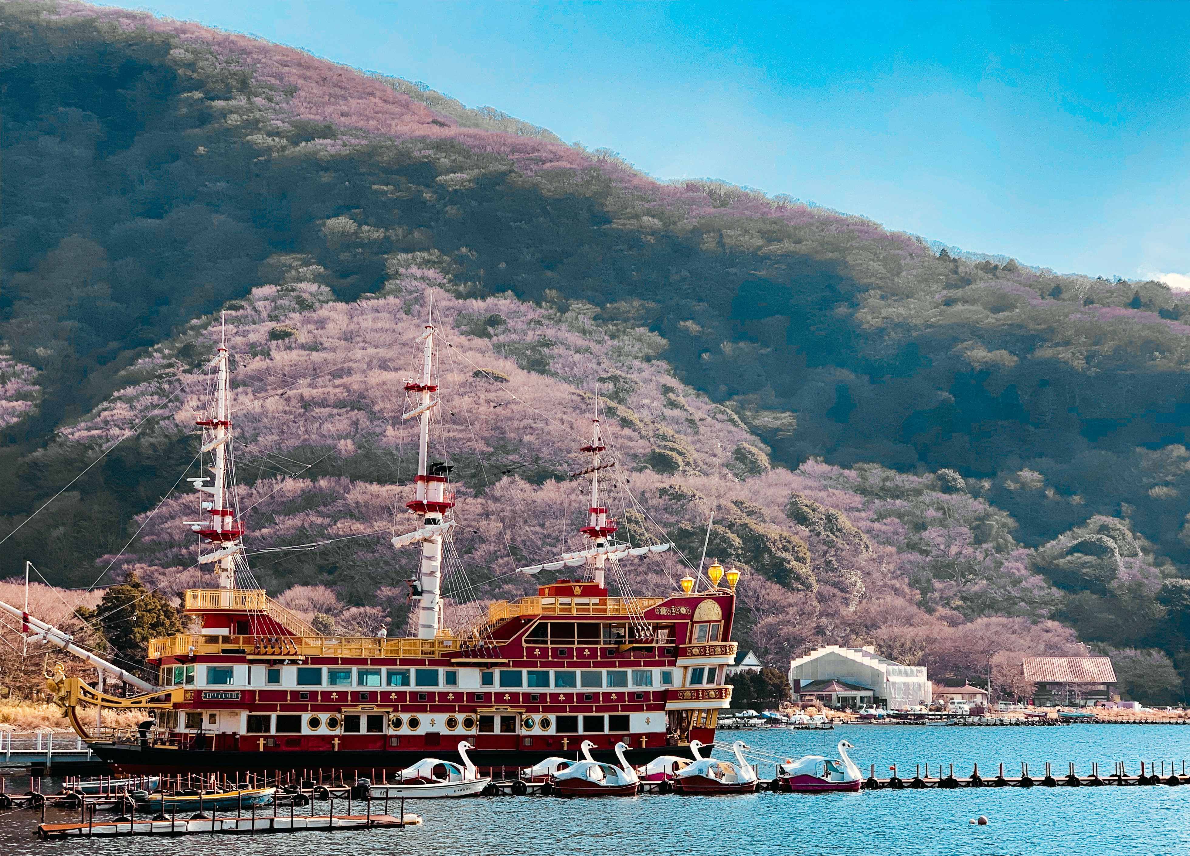 brown ship on sea near mountain during daytime