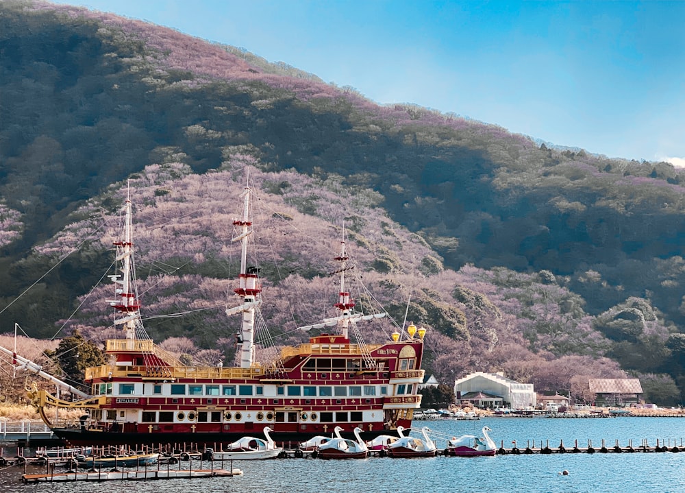 brown ship on sea near mountain during daytime