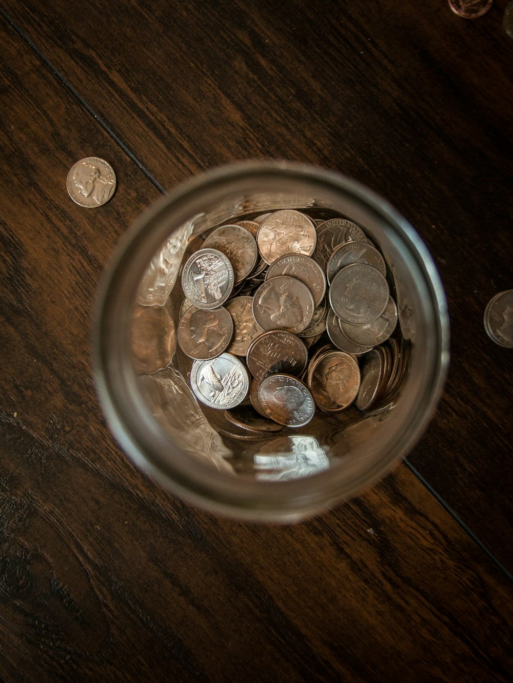 silver round coins on clear glass jar