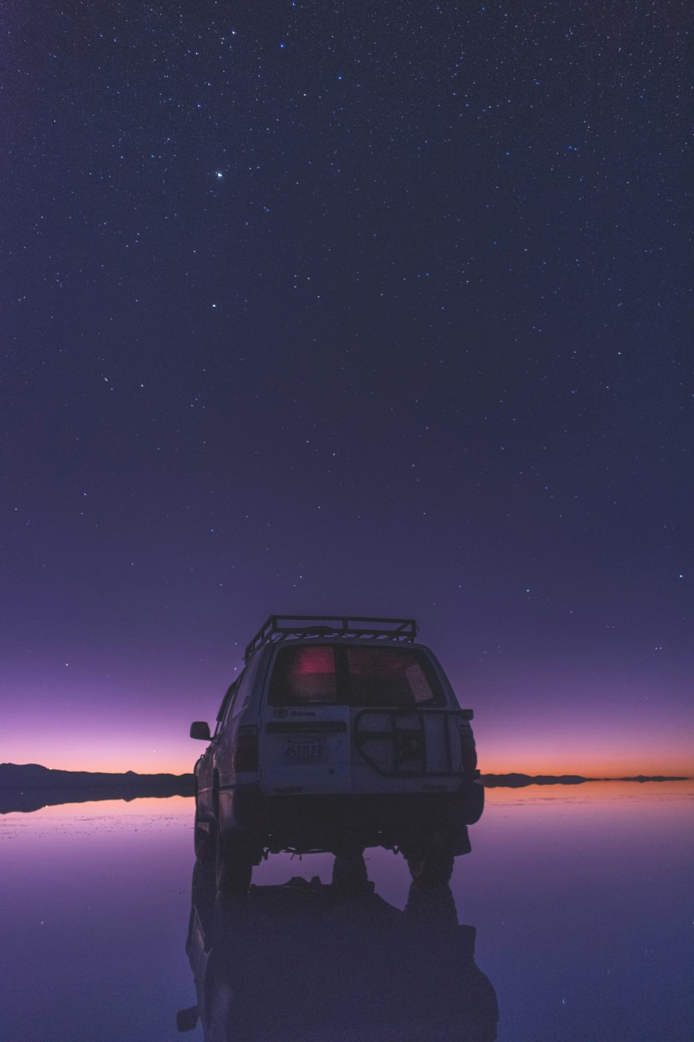 black suv on snow covered ground during night time