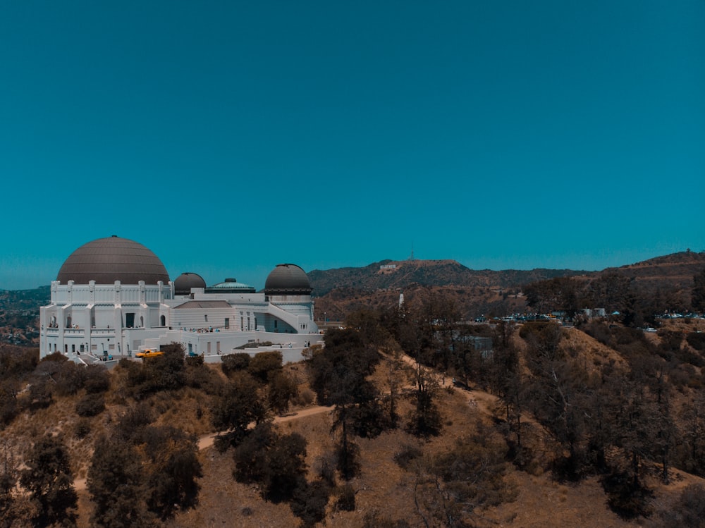 white dome building on brown and green mountain under blue sky during daytime