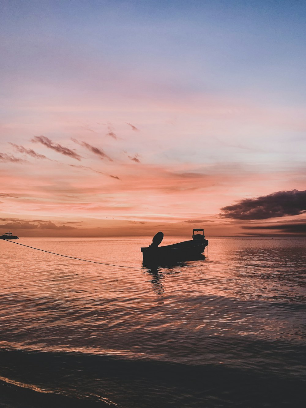 Silhouette eines Mannes, der bei Sonnenuntergang auf dem Boot fährt