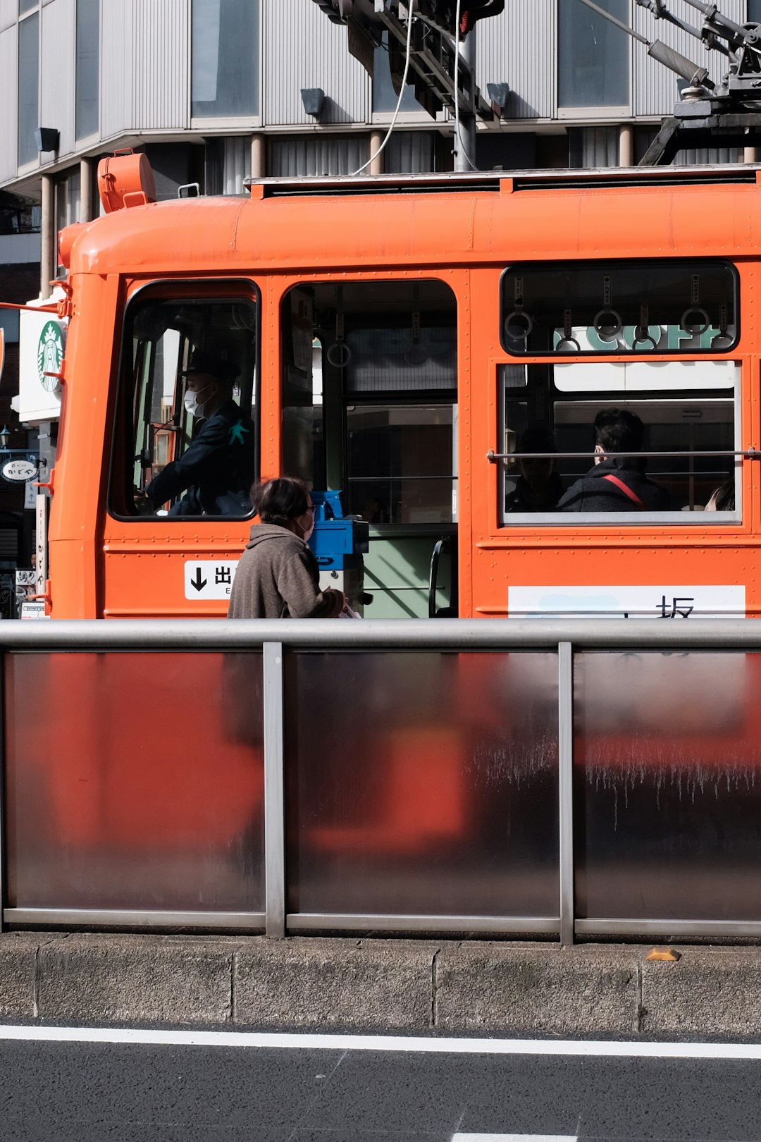 person in blue denim jeans sitting on red bus