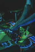 person playing audio mixer with green lights