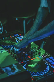 person playing audio mixer with green lights