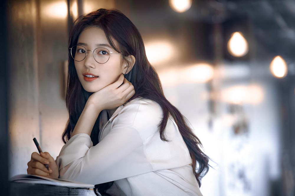 woman in white long sleeve shirt wearing black framed eyeglasses