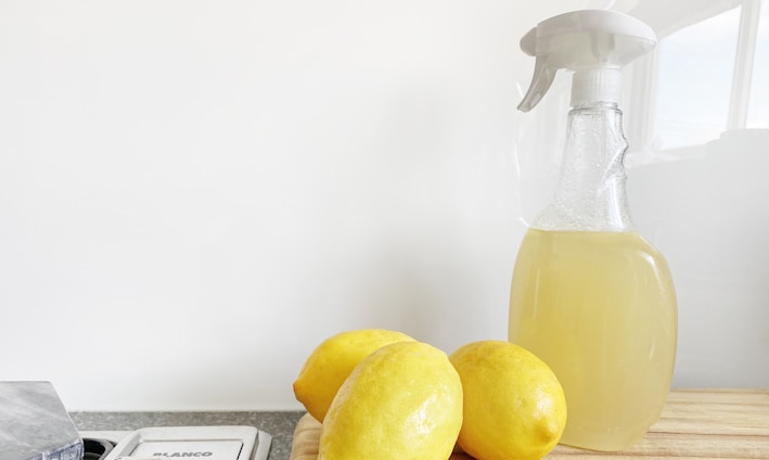 yellow lemon fruit beside clear glass bottle